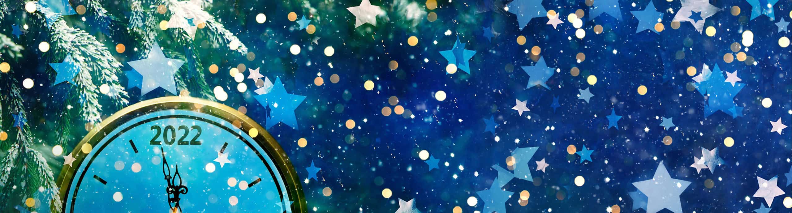 old fashioned analog clock almost midnight 2022 with snow, stars and glitters floating through the image