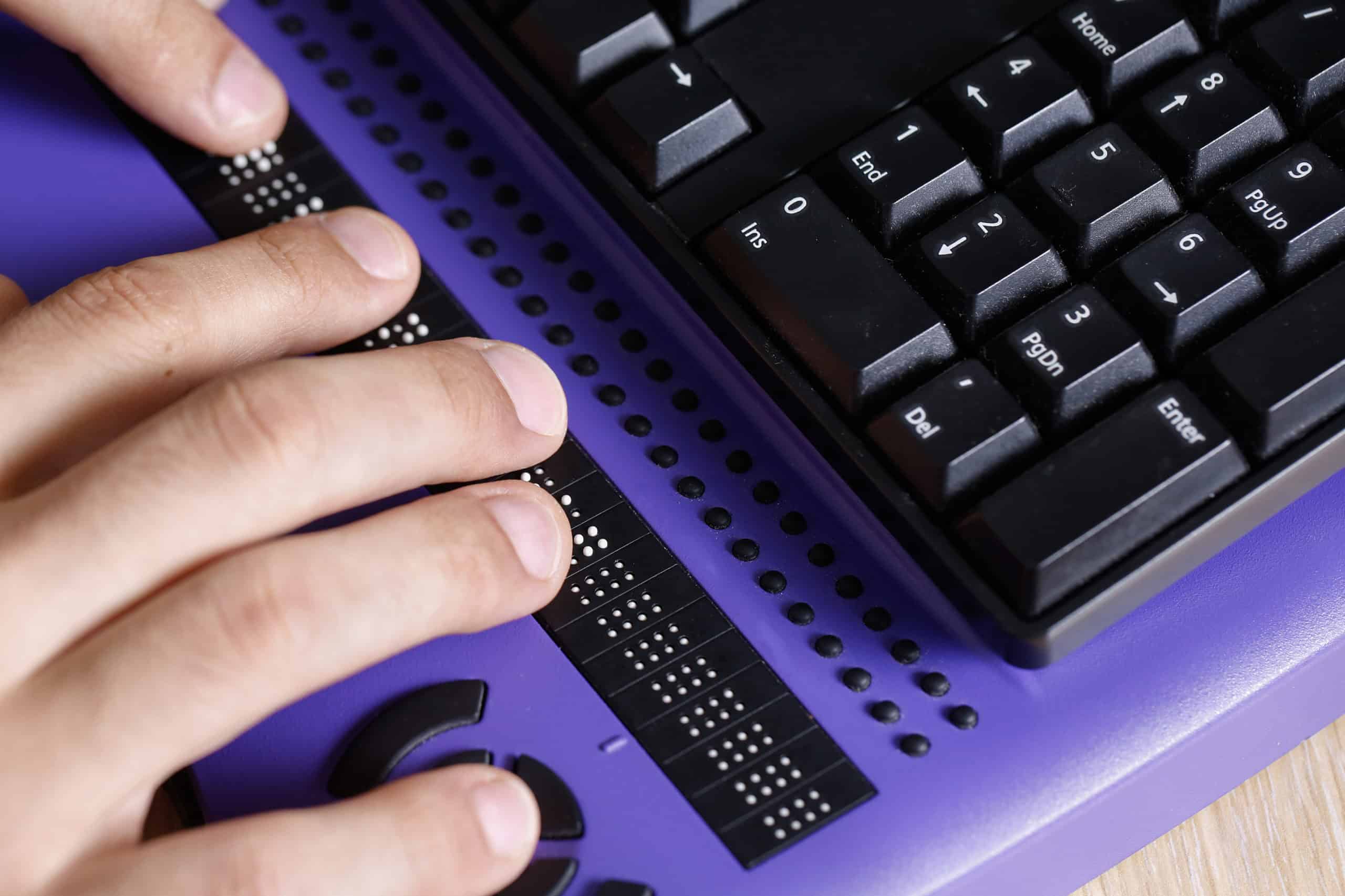A person who is blind uses a keyboard with a refreshable braille display.