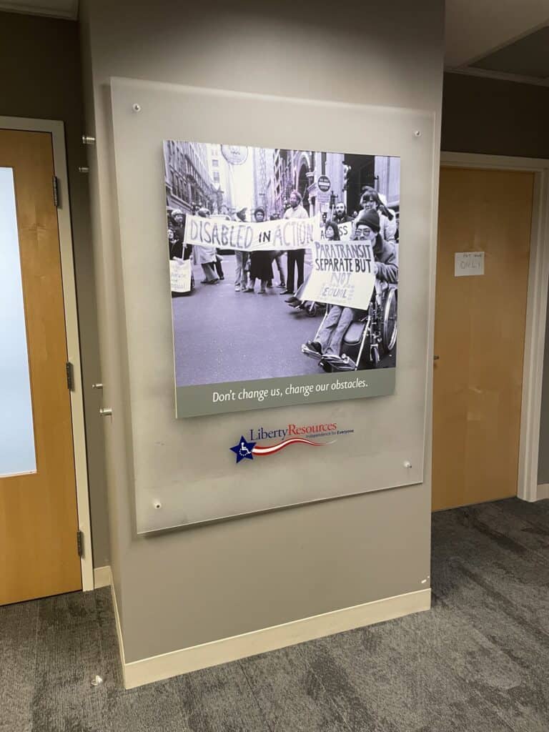 A poster showing people with disabilities protesting, with the following quote underneath. "Don't change us, change our obstacles."