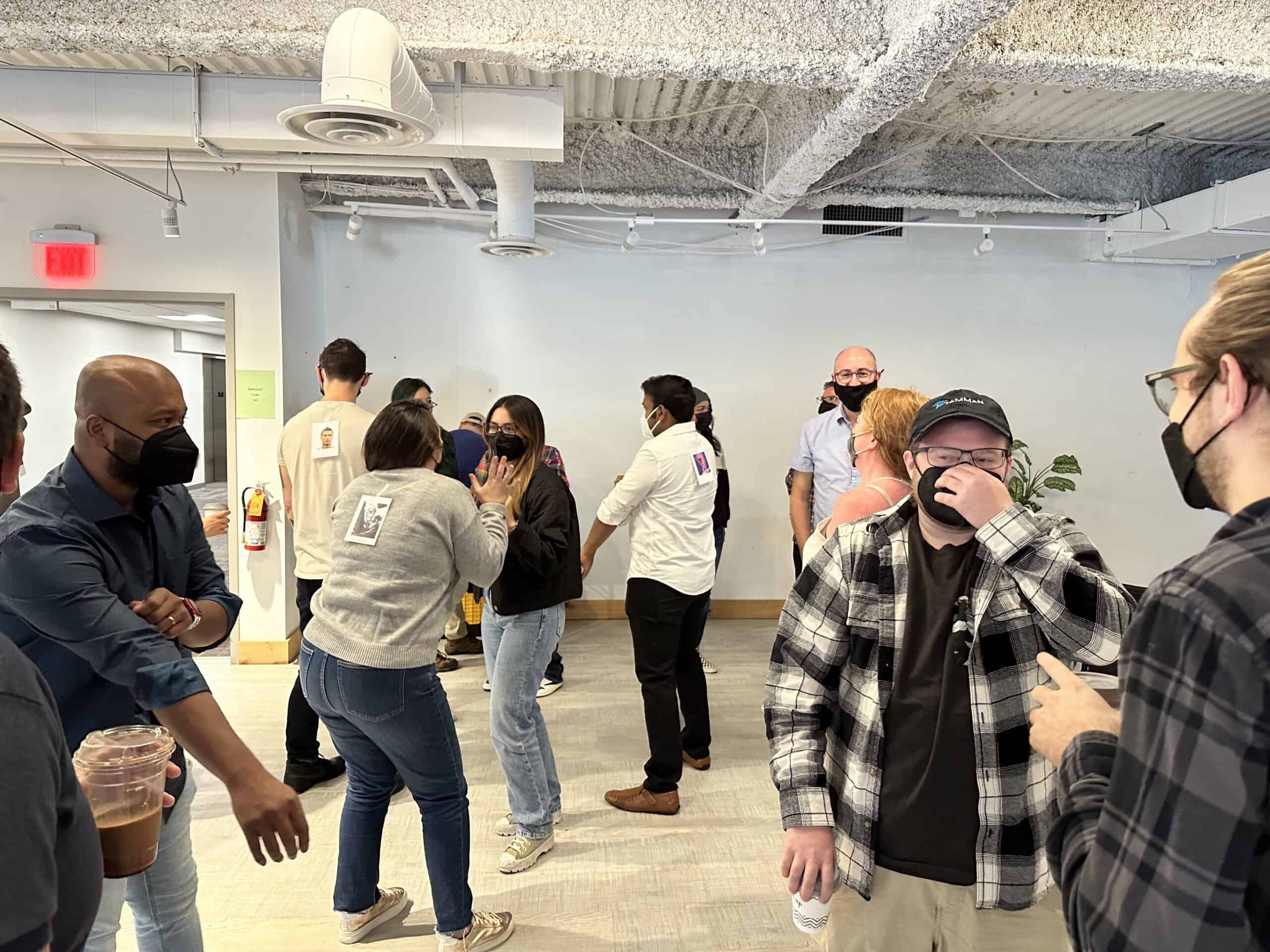 A large group of Tamman employees mingle while engaging in a guessing game.