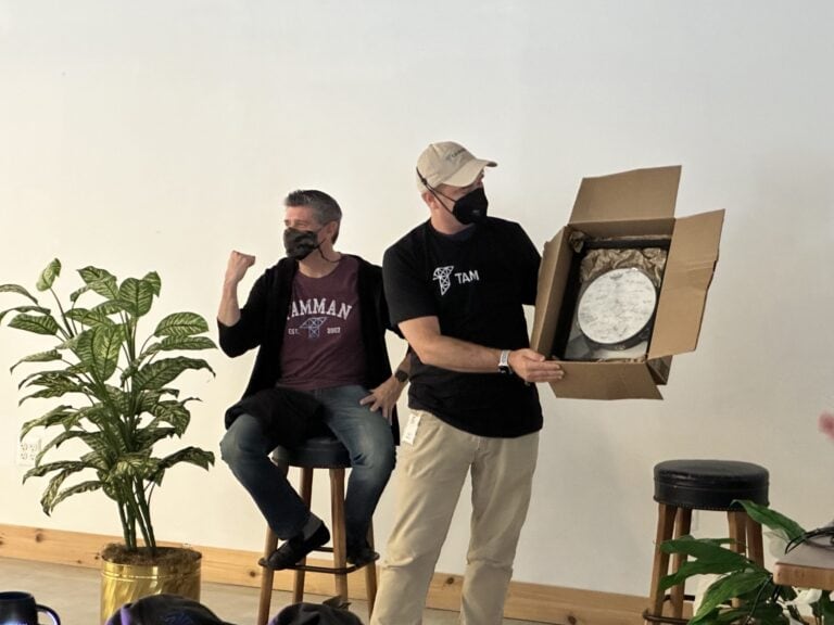 Tamman Inc. CEO Jeff Tamburino is presented a tambourine signed by all Tamman employees while doing a fist pump gesture.