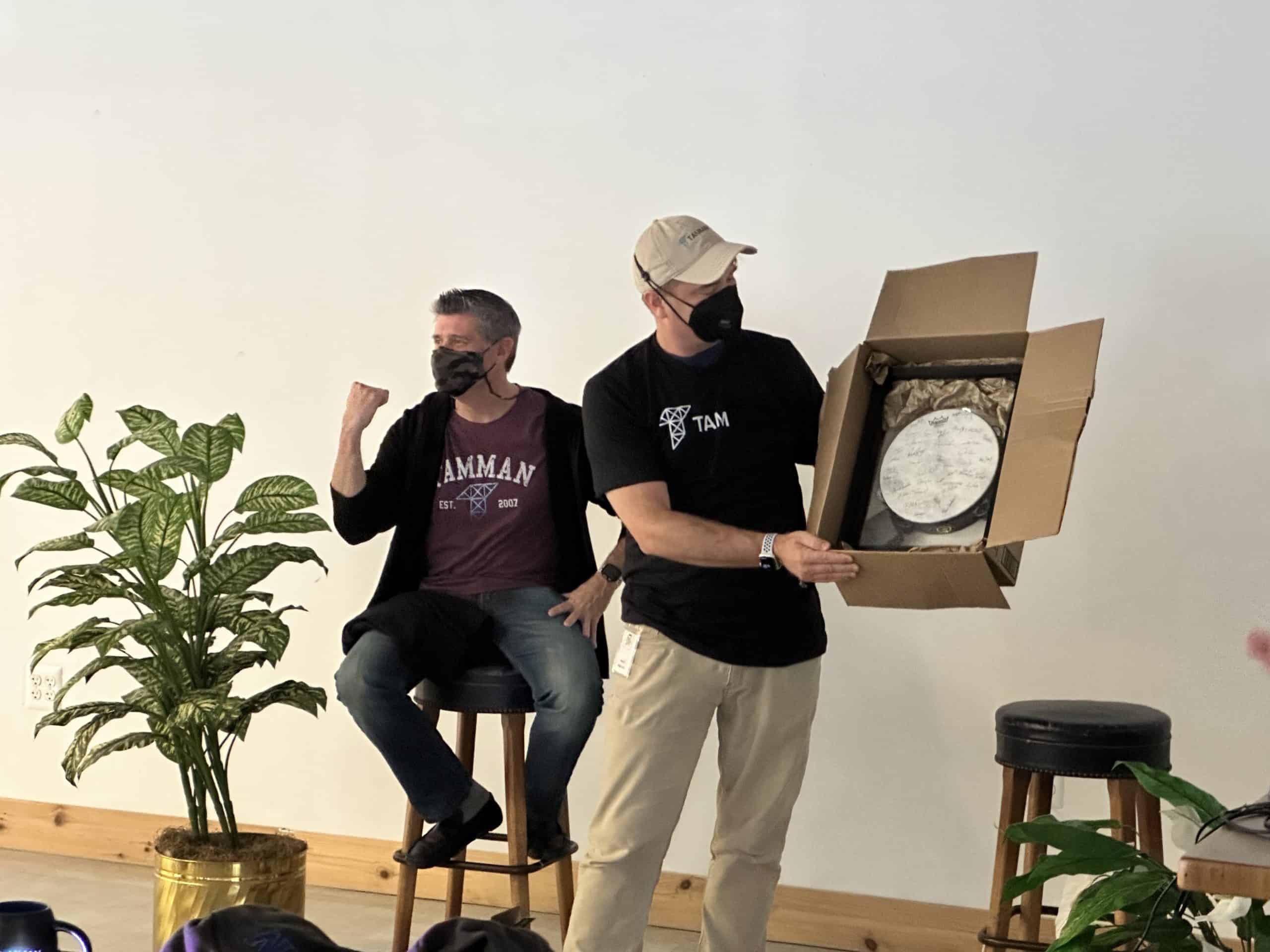 Tamman Inc. CEO Jeff Tamburino is presented a tambourine signed by all Tamman employees while doing a fist pump gesture.