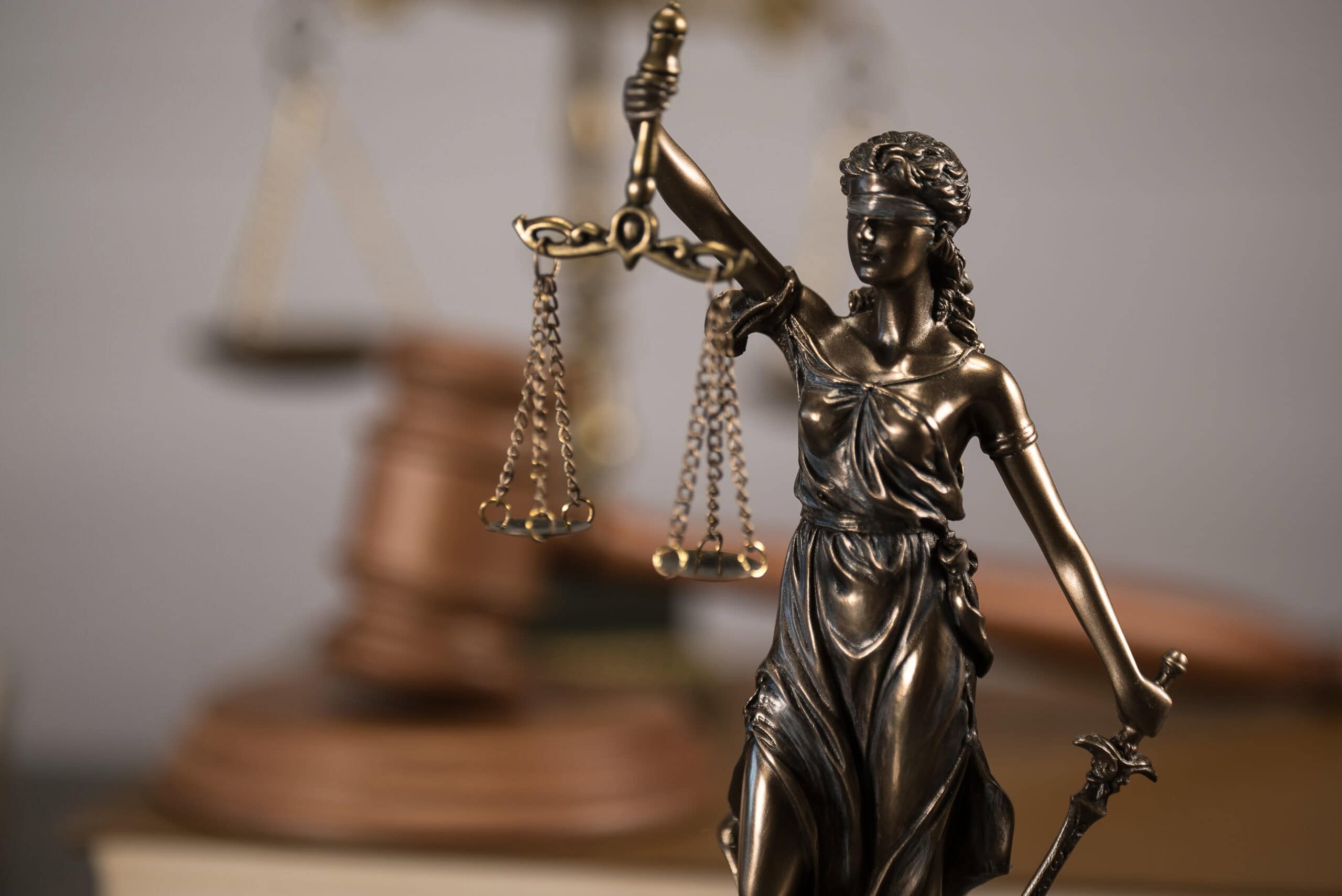 A statue of a blindfolded Lady Justice holding legal scales.