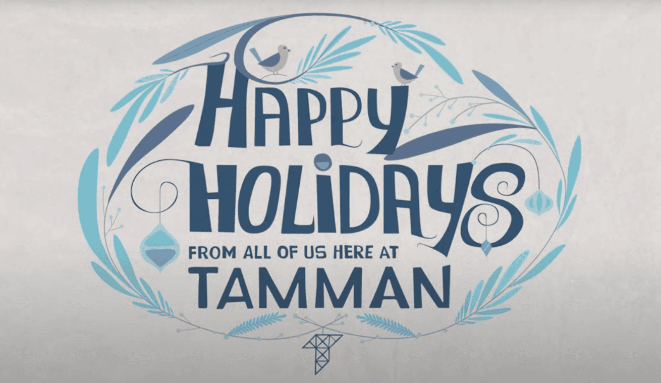 A light and dark blue holiday card graphic reads "Happy Holidays from all of us here at Tamman". The graphic includes lovely bluebirds, branches, rounded ice crystals, and the Tamman "T" logo.