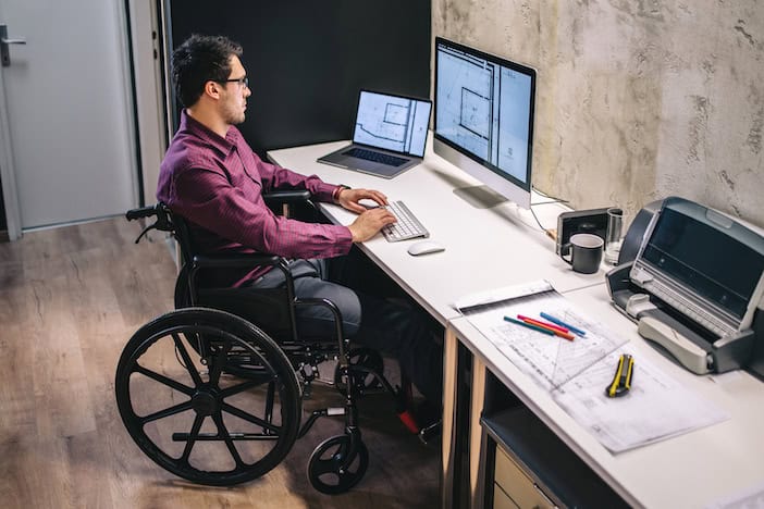 wheelchair user working at a desk in a modern office setting