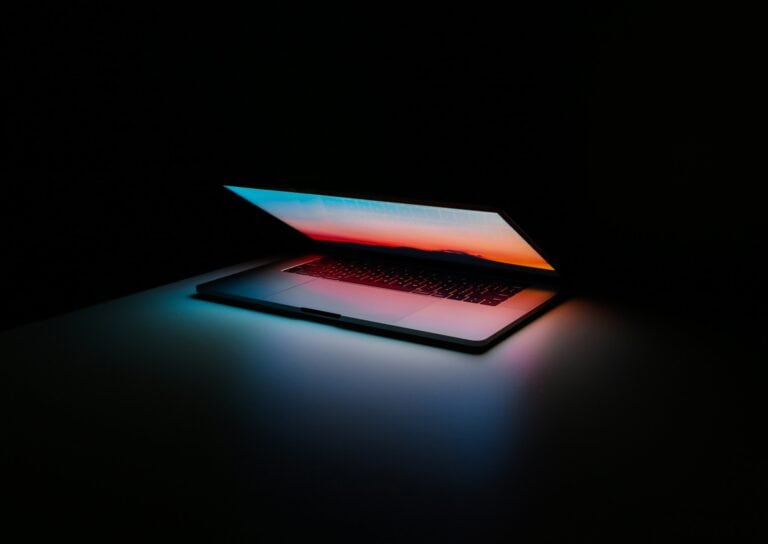 Half open colorful laptop screen set against a black backdrop