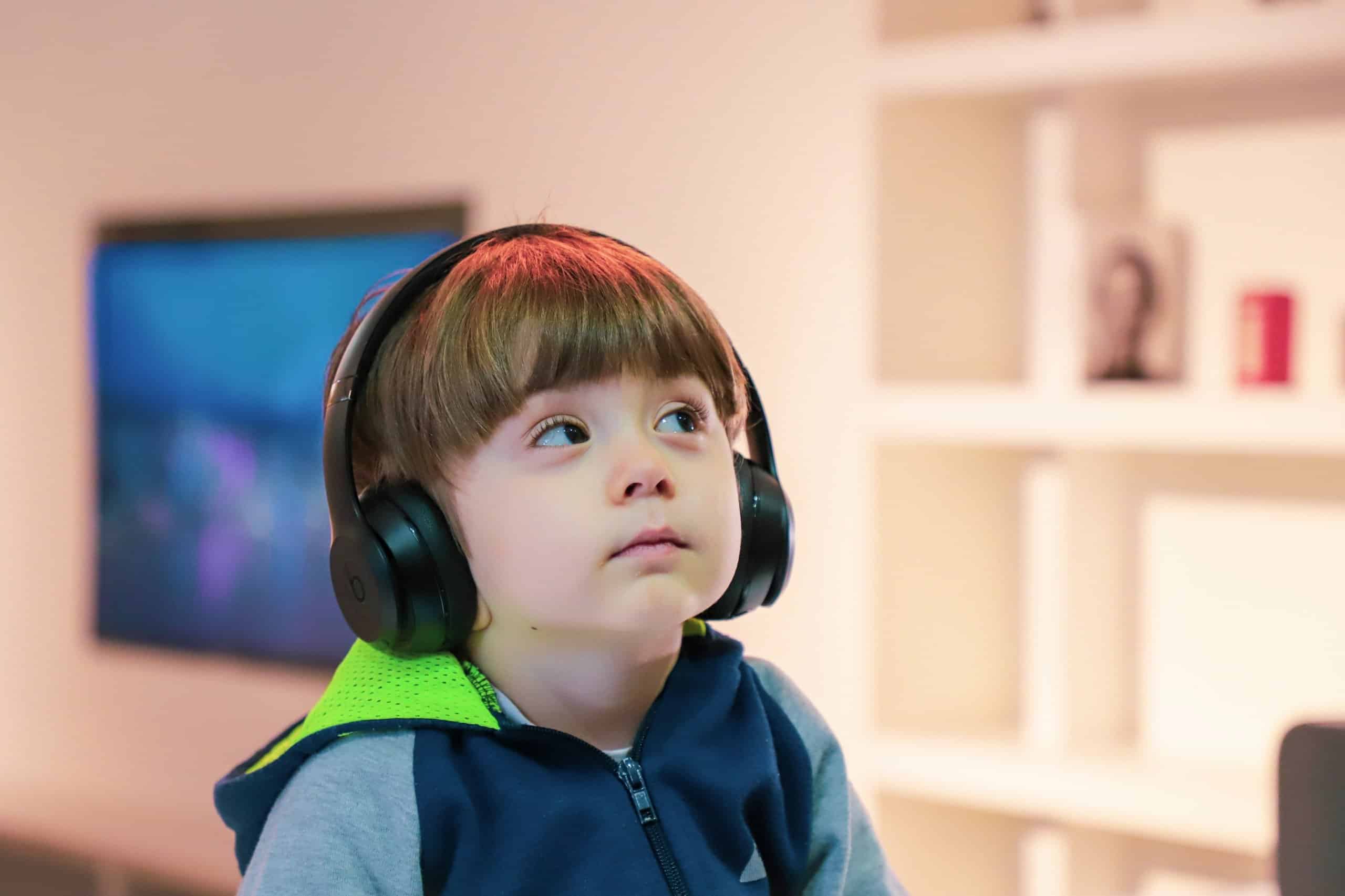 young child with headphones gazing up at an angle