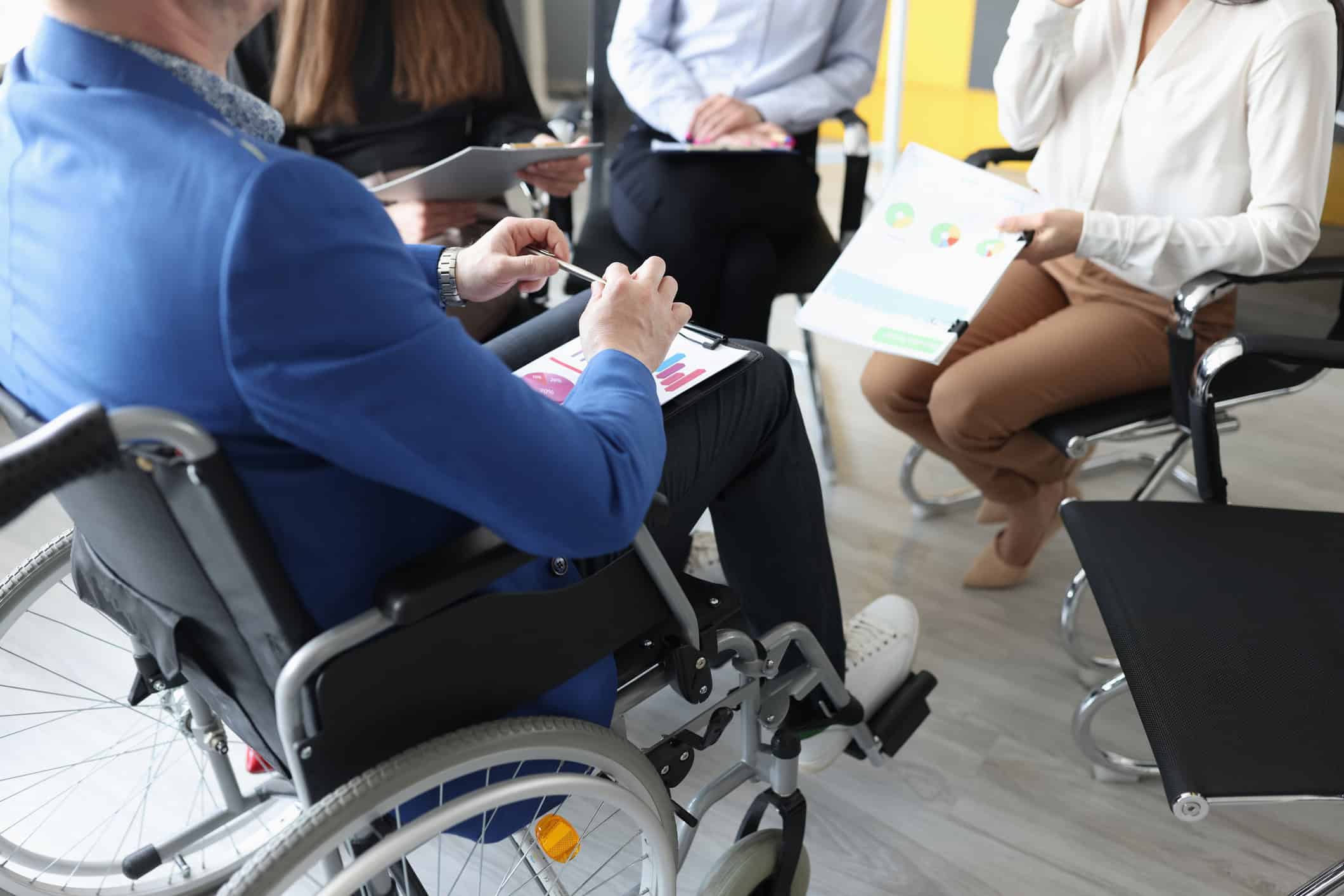 A man in a wheelchair attends a meeting.