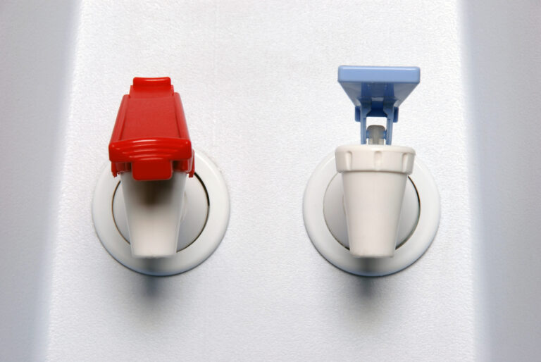 closeup of hot and cold faucet of water cooler