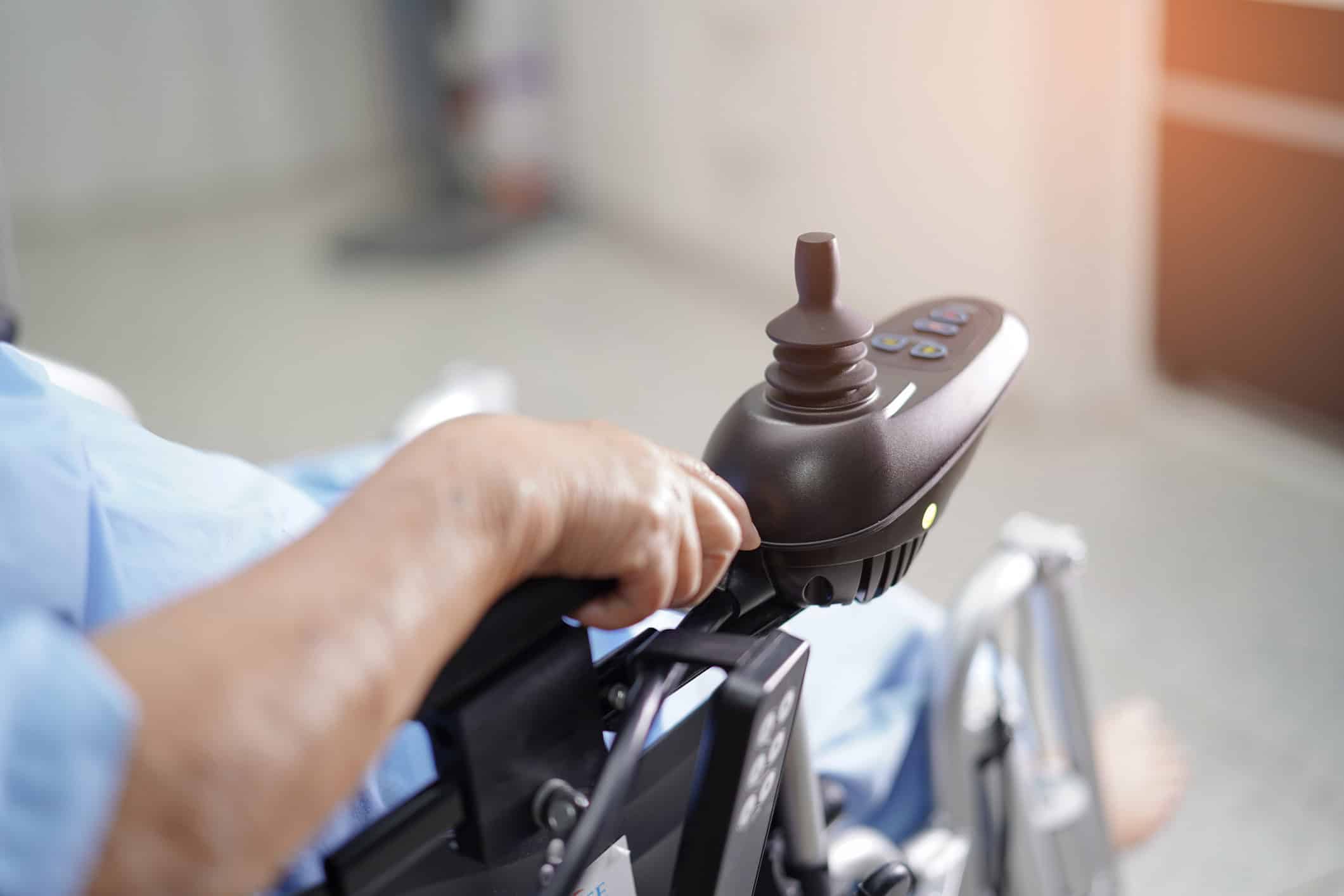 Patient Sitting On Motorized Wheelchair In Hospital