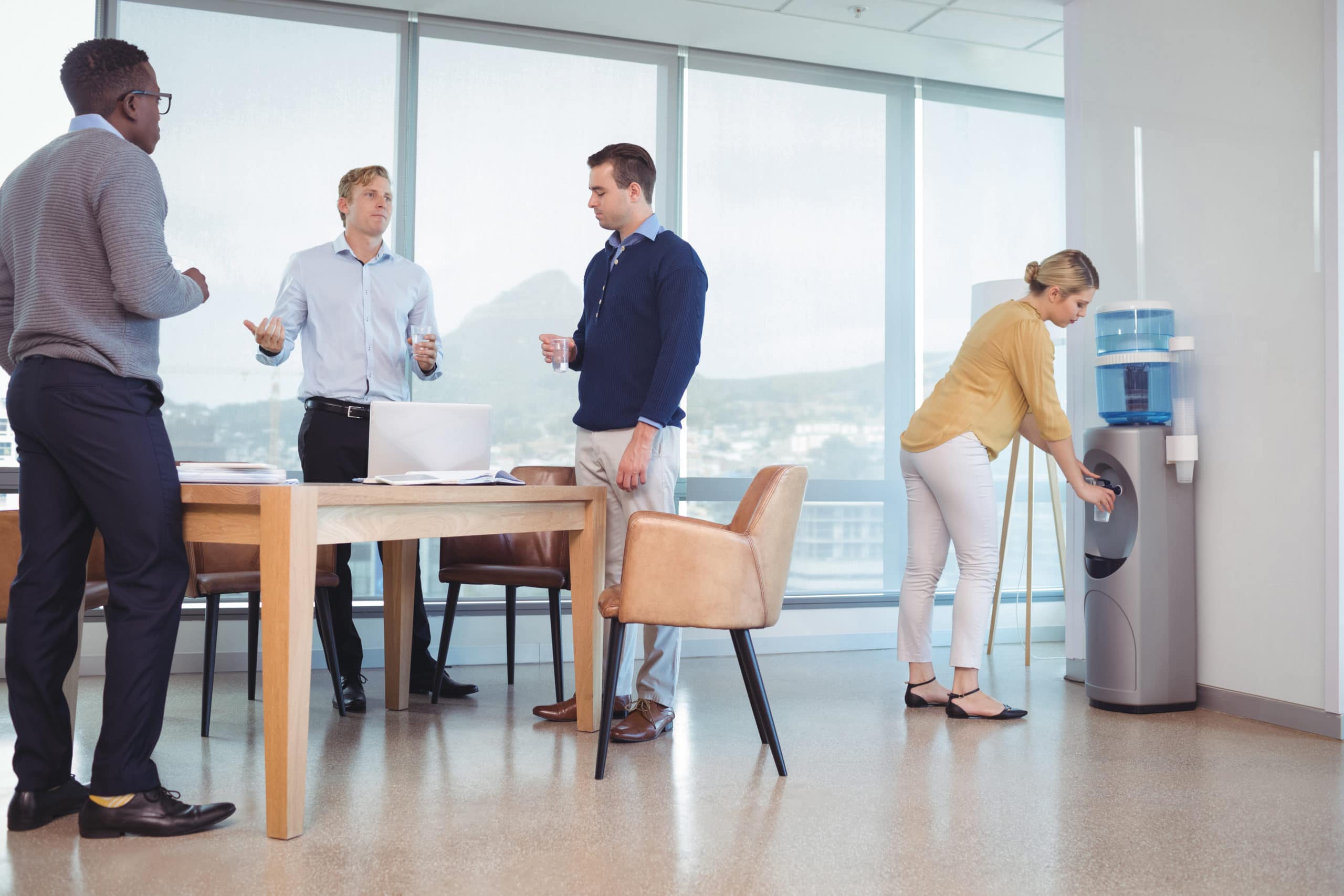 Business colleagues holding drinking glasses while standing at office cafeteria