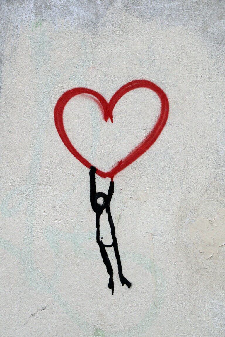 Stick figure hanging on or lifting up the bottom of a red line drawing of a heart