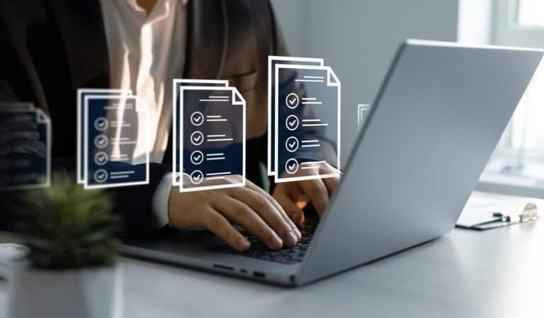 A closeup of a person on a laptop with document icons overlayed on the photo