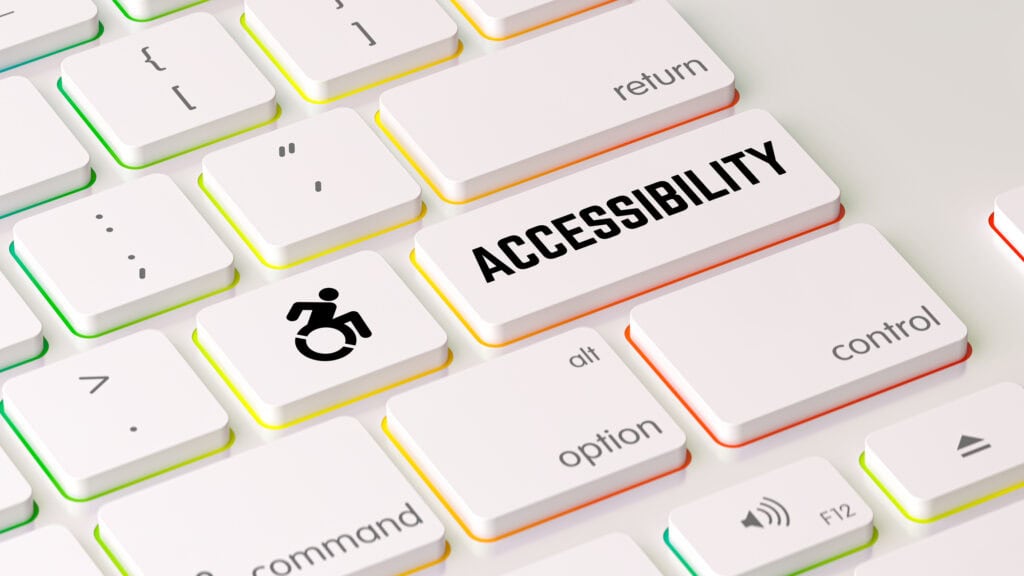 A close up of a white keyboard that has an icon of a person in a wheelchair on one key and the Enter key reads "Accessibility"