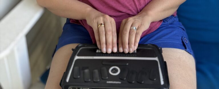 Kristen uses a refreshable Braille display that rests on her lap.
